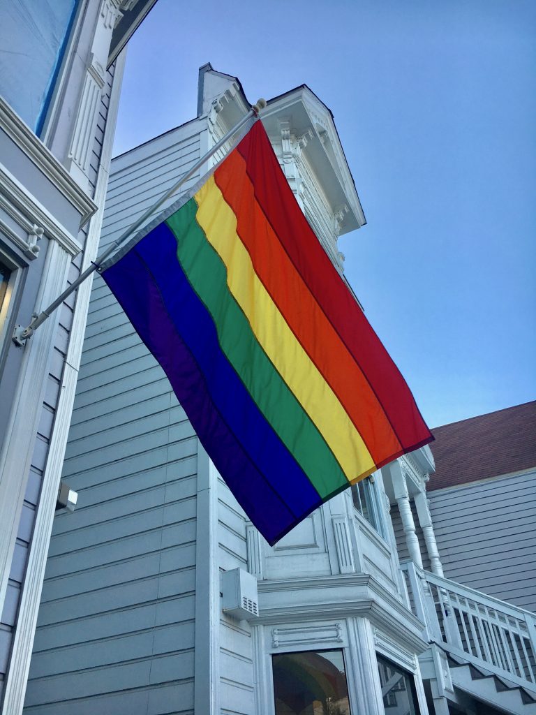A rainbow flag hangs on a house