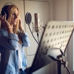 A vocalist works in a studio. Getty Images.