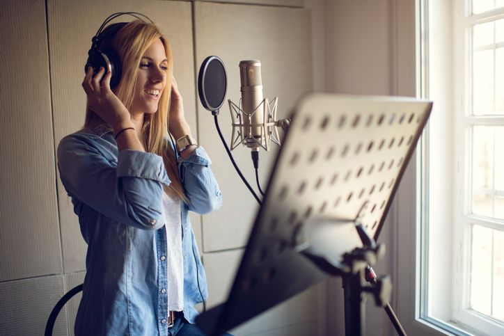 A vocalist works in a studio. Getty Images.