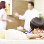 sad asian child and quarreling parents