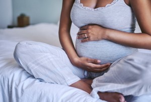Seated Pregnant Woman With Hands Over Stomach