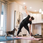 A Mature Woman Exercises With Her Dog On A Mat