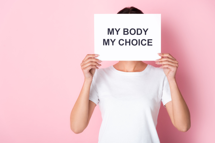 person holding placard that reads: My body my choice
