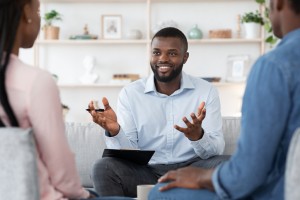 Family Psychotherapy. Friendly Black Therapist Consulting African American Couple At His Office