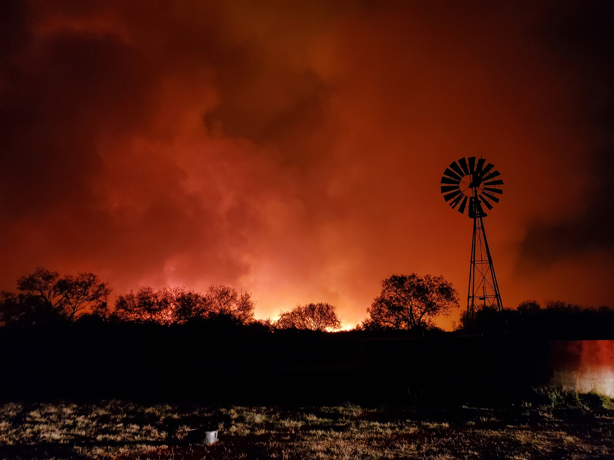 A wildlfire brightens the night sky in Texas, burning though farmland.