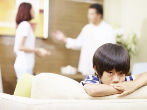 sad asian child and quarreling parents
