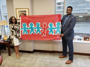 NASW CEO Angelo McClain and Governance Associate Doreta Richards display the Children's Memorial Flag at NASW headquarters.