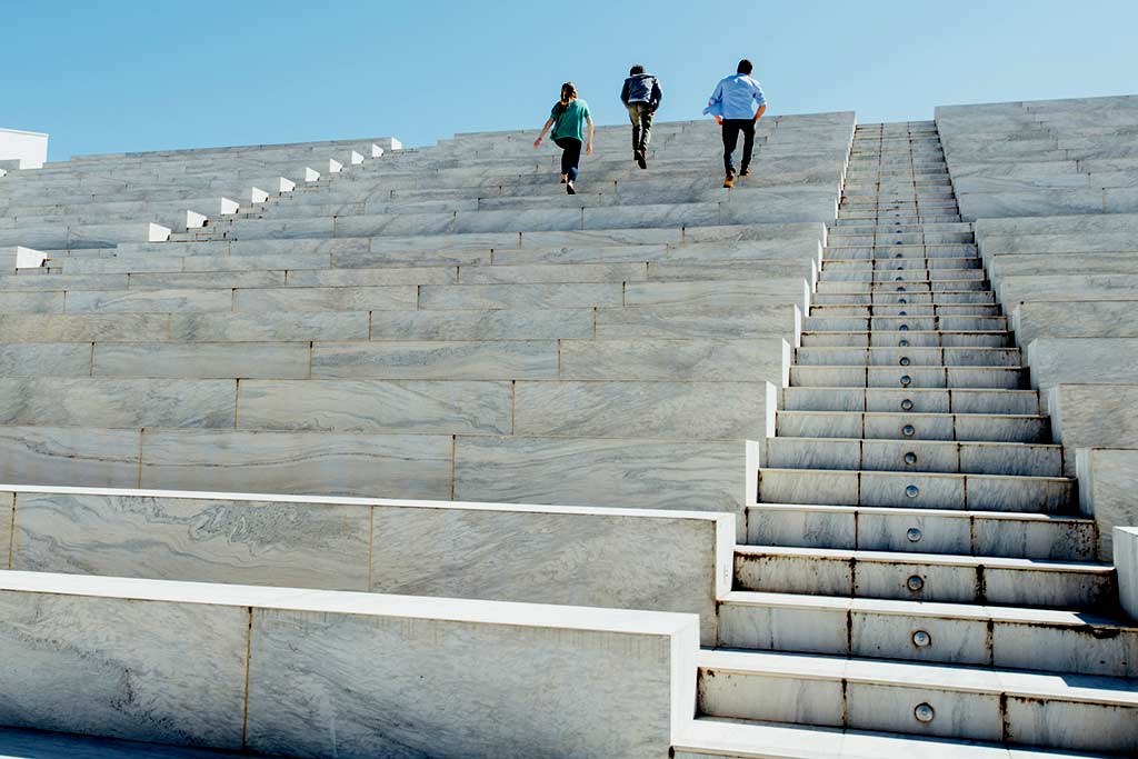 people running to the top of a marble staircase outdoors